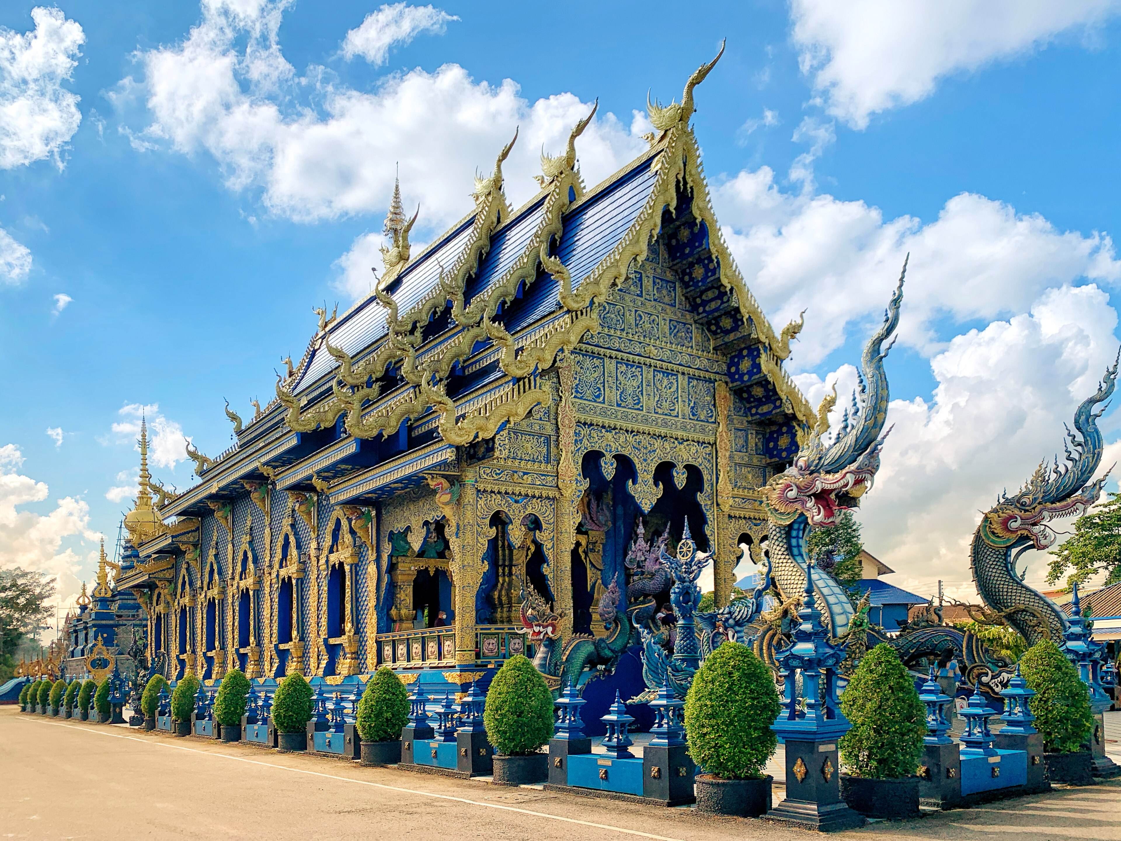The deep-blue and gold hall of Wat Rong Suea Ten, the Blue Temple, with naga statues at the entrance